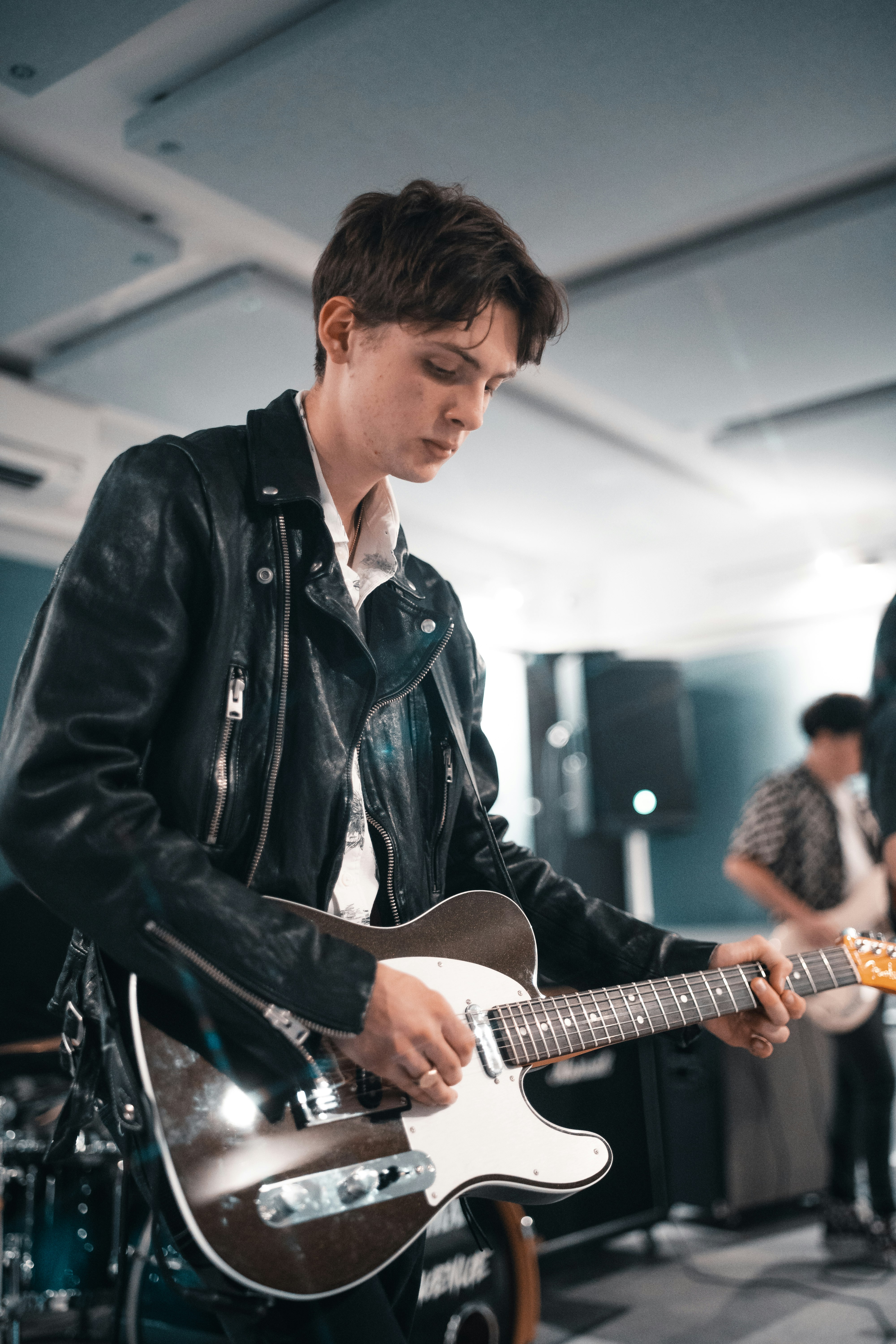 man in black leather jacket playing guitar